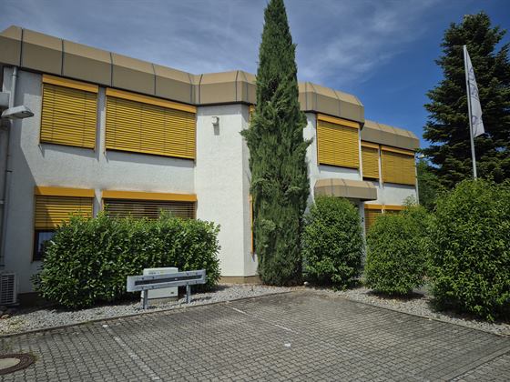 Außenansicht des Bürogebäudes mit Besucherparkplätzen direkt vor dem Haus